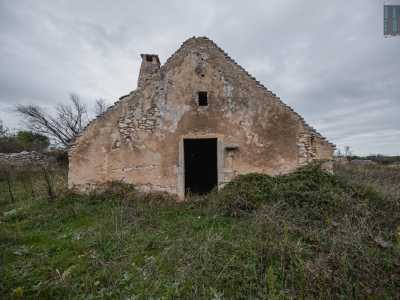 Ci avviciniamo dinanzi alla facciata triangolare della prima costruzione, chiaramente segnata dal passare del tempo e assediata dalla vegetazione spontanea